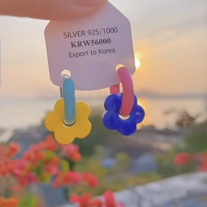 Detail showing 925 silver flower earrings with colorful contrast and beach vacation vibe