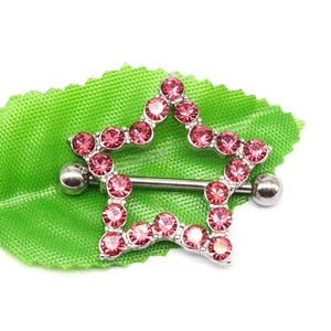 Detail of star-shaped nipple ring with pink rhinestones on a green leaf background