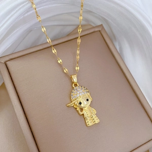 Macro shot of gold boy pendant with crystal cap on a flat chain necklace and jewelry box