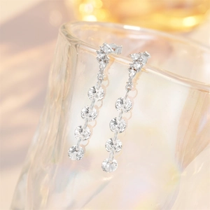 Close-up of elegant S925 silver long tassel earrings with sparkling crystals on glass