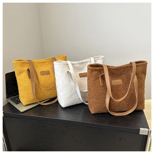 Detailed close-up of fashion tote bags in yellow, white, and brown with leather straps
