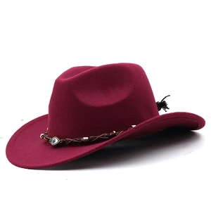 Detail of burgundy wool western hat with woven leather band and evil eye charm