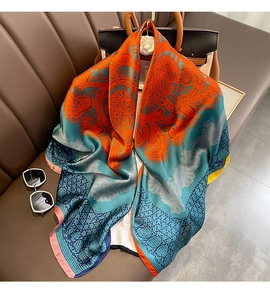 Détail d'une écharpe en soie à motifs floraux sur canapé et sac à main