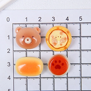 Detailed view of miniature resin food charms on measuring mat for DIY crafts