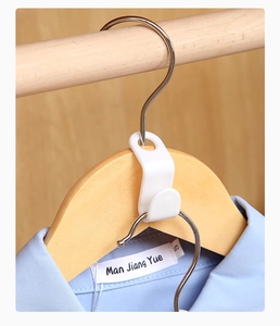 Close-up of white plastic clothes hanger connector hooks showing vertical stacking design
