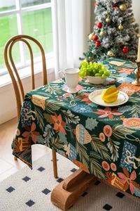 Detailed view of jacquard woven Christmas tablecloth with festive motifs on wooden table
