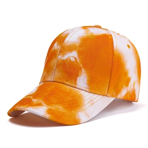 Detailed view of tie-dye baseball cap with vibrant orange and white canvas texture
