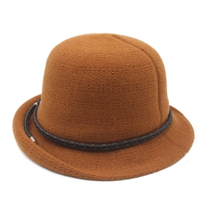 Close-up of caramel brown knitted bucket hat with braided leather band and silver buckle