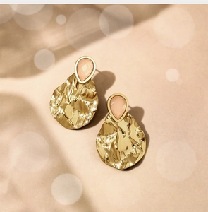 Detail of hammer textured gold teardrop earrings with pink aventurine natural stone inlay