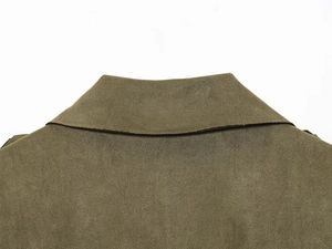 Detalle del cuello de una gabardina verde oliva con textura de ante y costuras precisas