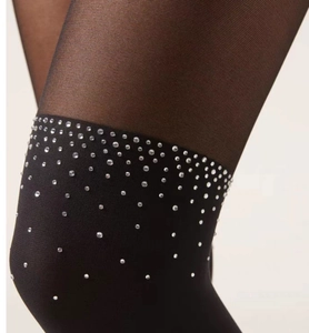 Detail of black faux thigh-high stockings with sparkling rhinestones and lace texture