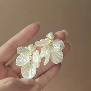 Detailed view of 925 silver needle pearl flower tassel earrings held in hand
