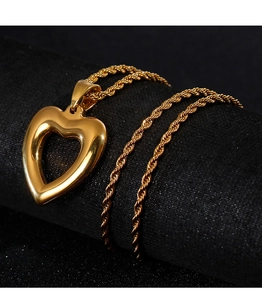Close-up of golden hollow heart pendant on a classic rope chain with metallic texture