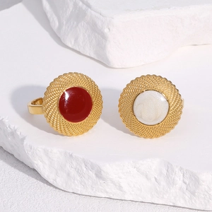 Detail view of retro 18k gold plated rings with red and white enamel on a stone base