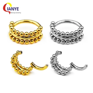 Macro detail of silver and gold beaded hinged segment clickers for nose or ear piercings