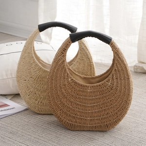 Handmade woven crescent straw bag set in beige and light brown with black leather handles