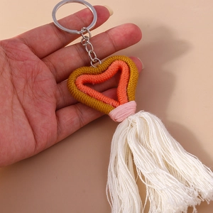 Detailed view of handmade knitted heart keychain with colorful tassels and metallic ring