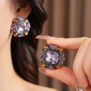 Macro detail of vintage square purple crystal earrings with colorful rhinestone settings