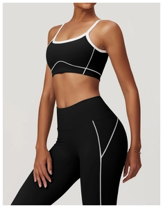 Détail de l'ensemble de yoga noir avec bordures contrastées blanches sur brassière et legging