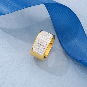 Macro shot of 18k gold plated stainless steel ring with pavé crystals on blue silk ribbon