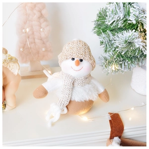 Detailed view of a plush Christmas snowman with a glitter hat in a cozy festive setting
