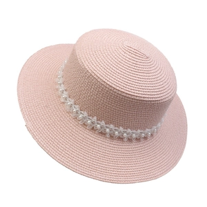 Detail of pink straw flat top boater hat with pearl beads and lace ribbon decoration