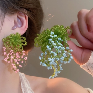 Detailed macro view of beaded flower tassel earrings in vibrant pink and blue colors