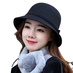 Set cappello a bombetta in lana nera e sciarpa di peluche grigia da donna su sfondo bianco