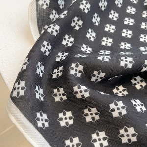 Macro shot of twill silk scarf with elegant black and white floral geometric pattern