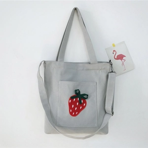 Light gray canvas tote bag with strawberry embroidery and adjustable shoulder strap