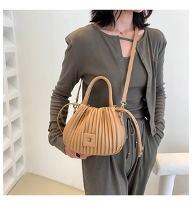 Detail view of the khaki pleated cloud bucket bag with textured vertical folds