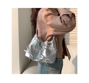 Detail showing metallic silver pleated PU leather shoulder bag with decorative bows
