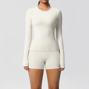 Detail of long sleeve yoga top and high waist shorts set in creamy white athletic fabric