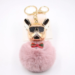 Dettaglio del portachiavi bulldog francese con testa dorata e pompon di peluche rosa