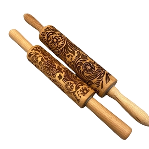 Christmas wooden rolling pins with floral and geometric engravings on a white background