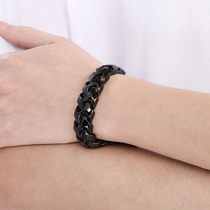 Close-up of black punk dragon bone chain bracelet with square clasp worn on a male wrist
