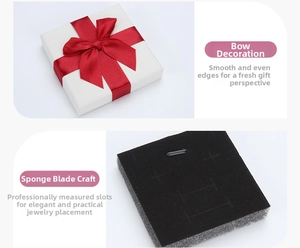 White textured jewelry gift box with a red ribbon bow and custom foam inserts
