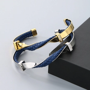 Detail of blue braided leather bracelets with gold and silver C-shaped diamond-set clasps