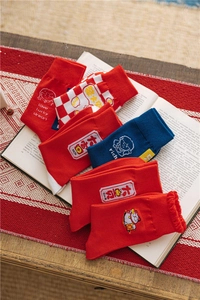 Detail view of festive red cotton socks with embroidery on a book, warm atmosphere