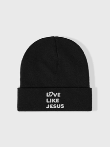 Detailed close-up of white LOVE LIKE JESUS embroidery on a black ribbed knit beanie hat