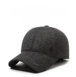 Detailed view of dark grey textured wool baseball cap with circular logo and ear flaps