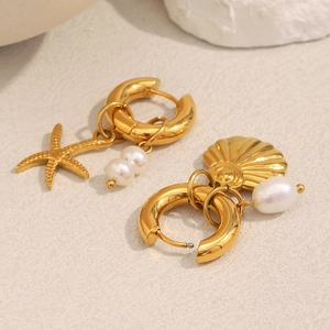 Close-up of 18K gold plated starfish and seashell pendants with white pearls on earrings