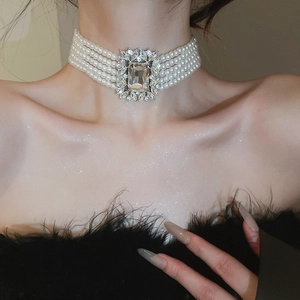 Close-up of multi-layer pearl choker with square gemstone centerpiece on model