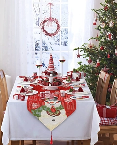 Detailed embroidery of snowman on red Christmas table runner with festive tassels