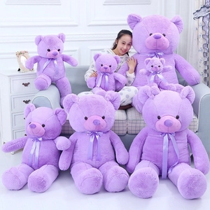 Various sizes of purple plush teddy bears with satin ribbons on a white sofa decor