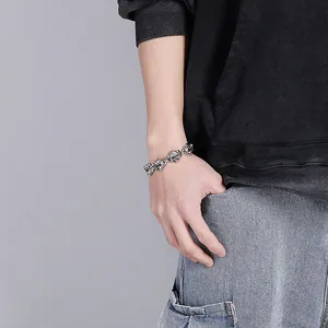 Gros plan du bracelet tête de mort en argent vintage en acier inoxydable au poignet