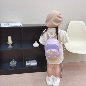 Toddler girl's purple unicorn backpack with sequins shown on child in home setting