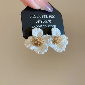 Detail of 925 silver flower earrings with white petals, gold stamen and zircon accents