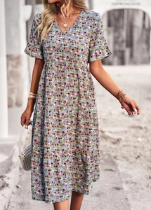 Detail of blue floral V-neck midi dress featuring layered ruffle hem and short sleeves