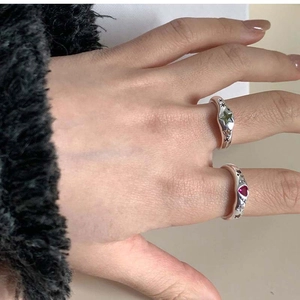 Detailed macro view of Y2K silver rings with green star and red heart-shaped zircon stones
